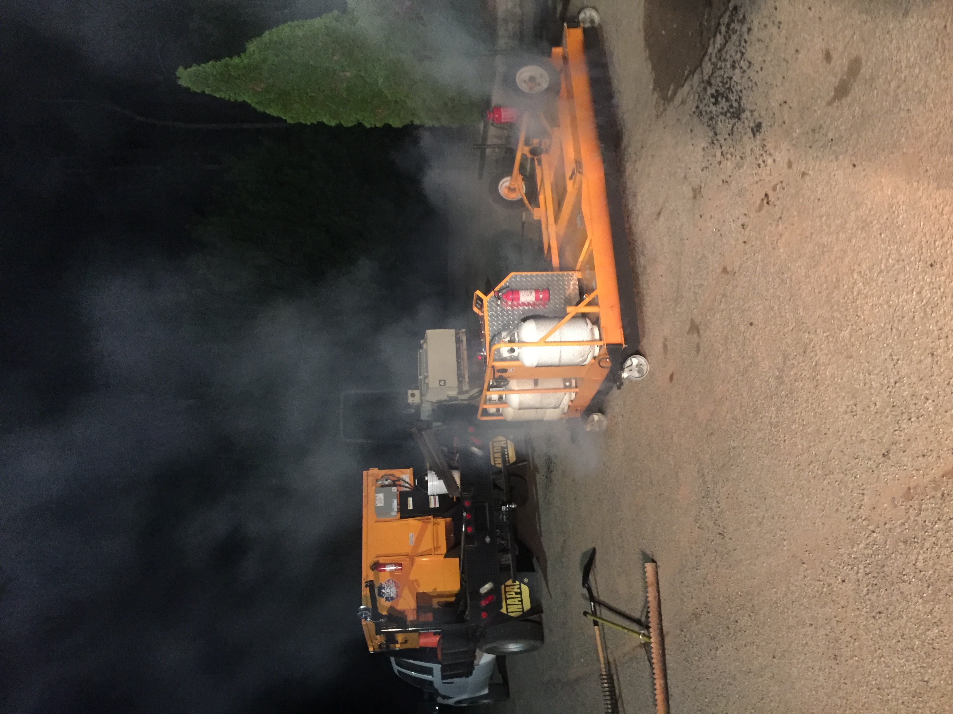 CCS crew performing infrared asphalt repair with machinery at night.